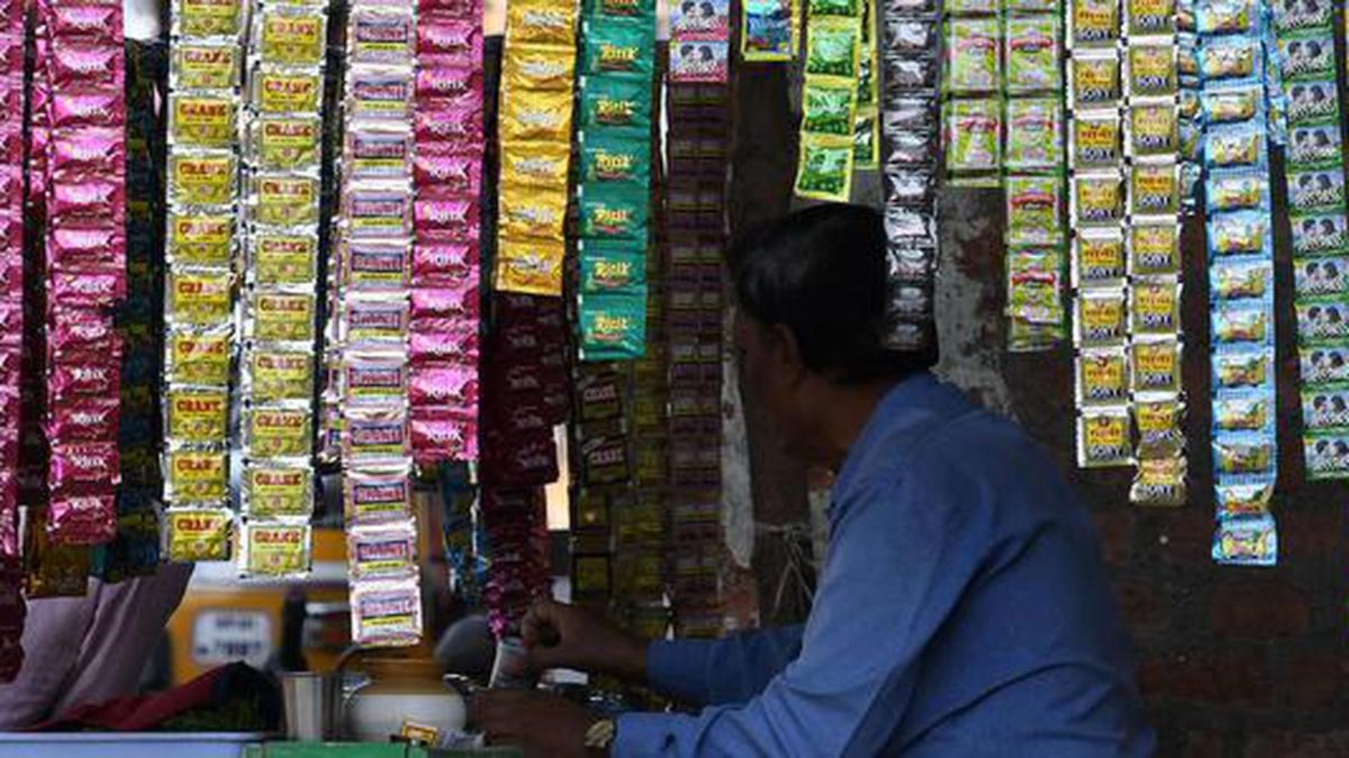 Hanging sachets of various tobacco brands in a street shop.